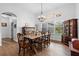 Dining room with wood floors, chandelier, farmhouse table, and a piano near a bright window at 30810 Nocatee Trl, Sorrento, FL 32776