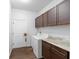 Convenient laundry room with washer, dryer, cabinets, and countertop space for folding and organizing at 30810 Nocatee Trl, Sorrento, FL 32776