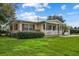 Ranch style home with carport, white picket fence, and well-manicured lawn at 3200 E Kaley Ave, Orlando, FL 32806