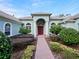 Inviting front entrance with a red door, brick walkway, and manicured landscaping at 4569 Old Carriage Trl, Oviedo, FL 32765