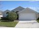 One-story house with attached garage, landscaping, and a light gray exterior at 603 Keppel Ct, Kissimmee, FL 34746