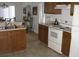 Kitchen with wood cabinets, white appliances, and a beige countertop at 603 Keppel Ct, Kissimmee, FL 34746