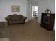 Living room with brown carpet, a brown couch, and a wood entertainment center at 603 Keppel Ct, Kissimmee, FL 34746
