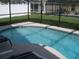 Refreshing kidney-shaped pool with a screened enclosure and patio at 603 Keppel Ct, Kissimmee, FL 34746
