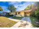 Front view of charming yellow house with driveway at 6150 Medford Dr, Orlando, FL 32808