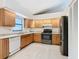 Kitchen with wood cabinets, granite countertops and black appliances at 936 Gillingham Ct, Kissimmee, FL 34758