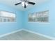 Light blue bedroom with wood-look floors and two windows at 992 Carnation Dr, Winter Park, FL 32792