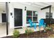 Inviting front porch with blue chairs and a black door at 992 Carnation Dr, Winter Park, FL 32792