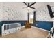 bedroom with navy blue wainscoting and playful wallpaper at 1016 Brooklet Dr, Davenport, FL 33837