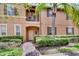 Front entrance of a two-story townhome with landscaping and brick walkway at 120 Palermo St, Davenport, FL 33897