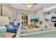 Living room with blue and green sofas, sliding glass doors, and open kitchen view at 120 Palermo St, Davenport, FL 33897