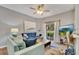 Living room with blue sofa, sliding glass doors to patio, and a large TV at 120 Palermo St, Davenport, FL 33897