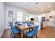 Open concept dining room with wooden table and blue chairs, adjacent to kitchen at 14025 Kauai Dr, Orlando, FL 32827