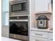 Built-in microwave and oven with a quartz countertop and white cabinets at 14025 Kauai Dr, Orlando, FL 32827