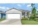 Single-story home with a white garage door and well-manicured lawn at 1705 Bent Branch Ave, Deland, FL 32720