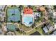 An aerial view shows tennis and basketball courts, swimming pool and clubhouse, nestled in a lush, tropical setting at 2556 Volta Cir, Kissimmee, FL 34746