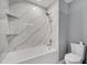 Clean bathroom with white bathtub and marble tile at 2556 Volta Cir, Kissimmee, FL 34746