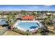 Community pool with lounge chairs, tables, and a covered pavilion, all nestled in a tropical landscape at 2556 Volta Cir, Kissimmee, FL 34746