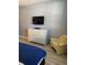 Comfortable bedroom showcasing a dresser with a TV and a cozy yellow chair at 3006 Bonfire Beach Dr # 102, Kissimmee, FL 34746