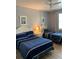 Comfortable bedroom with two beds, ceiling fan, and beach-themed artwork at 3006 Bonfire Beach Dr # 102, Kissimmee, FL 34746