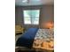 Bedroom featuring a quilt bed, wood flooring, and a chair next to a large window at 3006 Bonfire Beach Dr # 102, Kissimmee, FL 34746