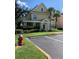 Front view of a charming yellow house with a green door, landscaping, and parking at 3006 Bonfire Beach Dr # 102, Kissimmee, FL 34746