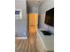 Hallway with wood floors leading to a white door and featuring a white dresser and flat screen TV at 3006 Bonfire Beach Dr # 102, Kissimmee, FL 34746