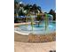 A zero entry splash pool with fountains surrounded by lush landscaping and colorful buildings at 3006 Bonfire Beach Dr # 102, Kissimmee, FL 34746