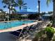 Community pool with lounge chairs and umbrellas, surrounded by landscaping and a gazebo at 3006 Bonfire Beach Dr # 102, Kissimmee, FL 34746