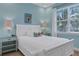 Charming bedroom with white sleigh bed, light blue walls, and coastal decor at 3088 Parrot Head Pl, Kissimmee, FL 34747