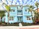Two-story light blue house with palm trees, walkway, and landscaping at 3088 Parrot Head Pl, Kissimmee, FL 34747