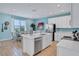 Bright kitchen with white cabinets, island, stainless steel appliances, and dining area at 3088 Parrot Head Pl, Kissimmee, FL 34747
