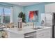 Kitchen island with sink, dishwasher, and ice maker, open to dining area at 3088 Parrot Head Pl, Kissimmee, FL 34747