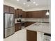 Modern kitchen with stainless steel appliances, granite countertops, and sleek brown cabinetry at 430 Captiva Dr, Davenport, FL 33896