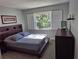 Bedroom with dark wood platform bed and window shutters at 5370 Whispering Pine Cir, Saint Cloud, FL 34771