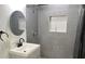 Updated bathroom with gray tile, a new vanity, and a walk-in shower at 5958 Lawnview Dr, Orlando, FL 32812