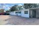 White house with teal accents, brick paver driveway, and modern entryway at 5958 Lawnview Dr, Orlando, FL 32812