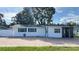 Updated white house with teal accents and brick paver driveway at 5958 Lawnview Dr, Orlando, FL 32812