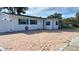 White house with teal accents, brick paver driveway, and fenced yard at 5958 Lawnview Dr, Orlando, FL 32812