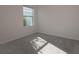 Sunlit bedroom with gray carpet and a window at 613 Greymount St, Davenport, FL 33837