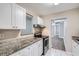 Updated kitchen with white cabinets and stainless steel appliances at 613 Ross St, Leesburg, FL 34748