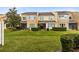 Back exterior of townhome with small patio and grassy area at 10125 Shadow Leaf Ct, Orlando, FL 32825