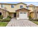 Inviting two-story townhome boasts a charming exterior, featuring stone accents and a paved driveway at 10125 Shadow Leaf Ct, Orlando, FL 32825
