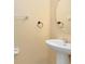 Clean and simple half bathroom with pedestal sink and mirror at 10125 Shadow Leaf Ct, Orlando, FL 32825