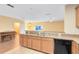 Modern kitchen with breakfast bar, wood cabinets, and black appliances at 10125 Shadow Leaf Ct, Orlando, FL 32825