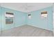 Light blue bedroom with two windows, carpet, and ceiling fan at 11113 Scenic Vista Dr, Clermont, FL 34711
