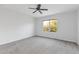 Spacious bedroom with grey carpet, ceiling fan, and large window at 11113 Scenic Vista Dr, Clermont, FL 34711