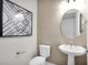 Powder room with pedestal sink, toilet, and modern decor at 13714 Fresh Ivy St, Winter Garden, FL 34787