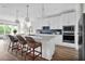 Modern kitchen with white cabinets, blue backsplash and island at 13714 Fresh Ivy St, Winter Garden, FL 34787