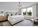 Main bedroom with large bed, neutral decor, and backyard view at 13714 Fresh Ivy St, Winter Garden, FL 34787